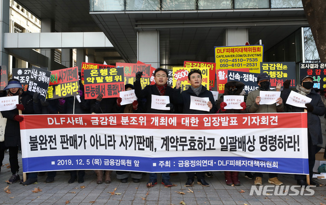 [서울=뉴시스] 이영환 기자 = 금융정의연대 법률지원단장 신장식 변호사 및 DLF피해자대책위원회 관계자들이 5일 오후 서울 영등포구 금융감독원 앞에서 열린 'DLF사태, 금감원 분조위 개최에 대한 입장 발표 기자회견'에 참석해 구호를 외치고 있다. 2019.12.05. 20hwan@newsis.com