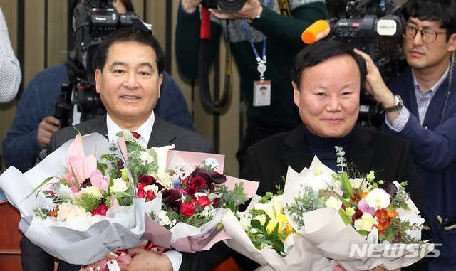 [서울=뉴시스] 이종철 기자&nbsp; = 자유한국당 새 원내대표에 선출된 심재철 의원과 정책위의장에 선출된 김재원 의원이 9일 오전 서울 여의도 국회에서 열린 의원총회에서 꽃다발을 들고 있다. 2019.12.09. jc4321@newsis.com