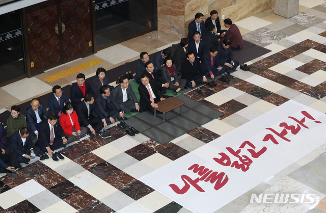[서울=뉴시스] 고승민 기자 = 자유한국당 황교안 대표와 심재철 원내대표를 비롯한 의원들이 11일 서울 여의도 국회 로텐더홀에서 패스트트랙 철회 등을 촉구하며 '무기한' 농성을 시작하고 있다. 2019.12.11. kkssmm99@newsis.com
