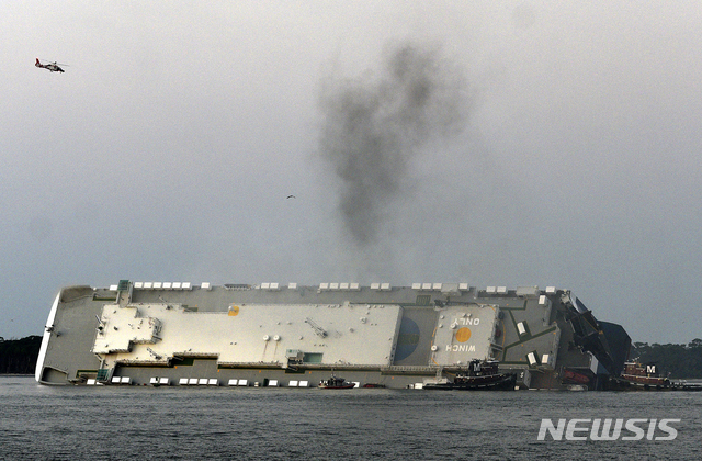 [AP/뉴시스] 2019년 9월8일 뒤집힌 골든 레이호에서 연기가 솟아오르고 있다. 승무원들은 모든 연료를 다 빼낸 뒤 배에서 탈출했고 이 배의 처리 문제는 일단 올해 10월초부터 절단, 철거하는 방향으로 결정되었다.&nbsp; 