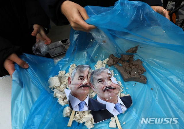 [서울=뉴시스] 이영환 기자 = 해리 해리스 주한미국대사 참수대회 참가자가 13일 오후 서울 종로구 주한미국대사관 인근에서 열린 참수대회에 참석해 묵사발 퍼포먼스를 마친뒤 정리를 하고 있다. 2019.12.13.   20hwan@newsis.com