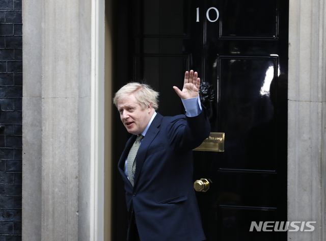 [런던=AP/뉴시스] 영국 총선에서 대승한 보리스 존슨 총리가 13일 새정부 구성을 허락받기 위해 버킹엄궁의 여왕을 예방해 20분을 머문 후 다시 총리관저로 돌아오면서 손을 흔들고 있다. 2019. 12. 13. 