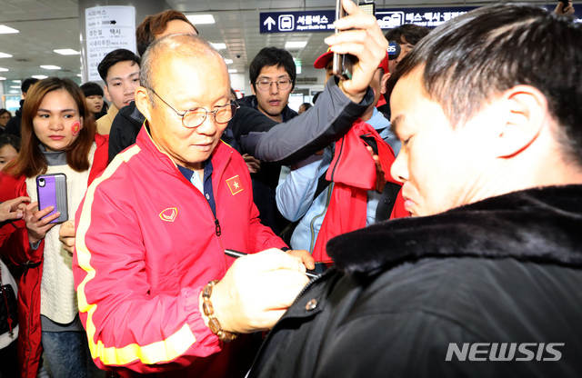 [김해공항=뉴시스]강종민 기자 = 60년 만에 동남아시아를 제패한 베트남 축구의 영웅 박항서 감독이 14일 오전 김해공항에 입국, 기다리던 팬들에게 사인을 해주고 있다. U-23 대표팀을 이끌고 온 박감독은 경남 통영에서 전지훈련을 할 예정이다. 2019.12.14.&nbsp; ppkjm@newsis.com