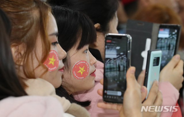 [김해공항=뉴시스]강종민 기자 = 14일 오전 김해공항 입국장에서 박항서 베트남 축구 대표팀 감독을 기다리던 팬들이 휴대폰으로 촬영에 열중하고 있다. U-23 대표팀을 이끌고 온 박감독은 경남 통영에서 전지훈련을 할 예정이다. 2019.12.14. ppkjm@newsis.com