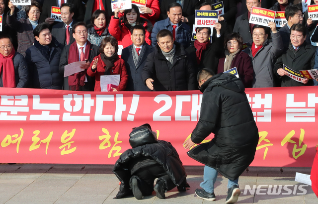 [서울=뉴시스]김명원 기자 = 자유한국당 황교안 대표와 의원들이 16일 오전 서울 여의도 국회 본청 계단앞에서 공수처법 선거법 날치기 저지 규탄대회중 한 당원이 큰절을 하고 있다. 2019.12.16.&nbsp; kmx1105@newsis.com 