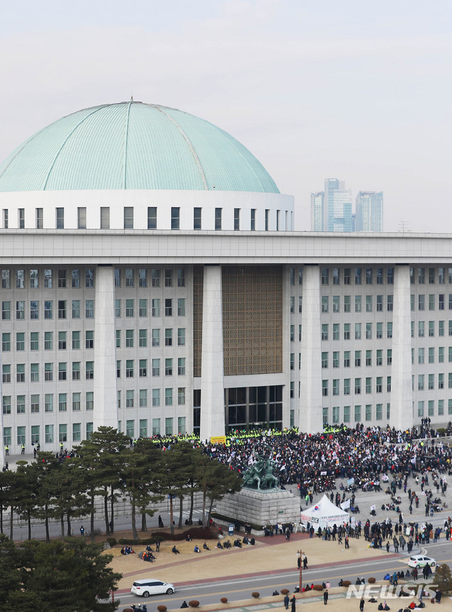 [서울=뉴시스] 장세영 기자 = 우리공화당 당원 등 보수단체 회원들이 16일 오전 서울 여의도 국회 본청 앞에서 태극기와 함께 공수처법, 선거법 반대 등이 적힌 손 팻말을 들고 구호를 외치고 있다. 2019.12.16. photothink@newsis.com