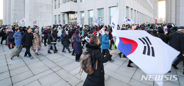 [서울=뉴시스] 장세영 기자 = 우리공화당 당원 등 보수단체 회원들이 16일 오전 서울 여의도 국회 본청 앞에서 태극기와 공수처법과 선거법 반대 등이 적힌 손 팻말을 들고 국회를 돌고 있다. 2019.12.16. photothink@newsis.com