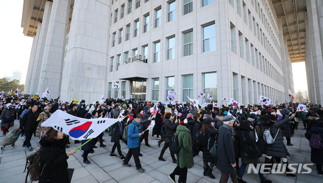 [서울=뉴시스] 장세영 기자 = 우리공화당 당원 등 보수단체 회원들이 16일 오전 서울 여의도 국회 본청앞에서 태극기와 공수처법과 선거법 반대 등이 적힌 손 팻말을 들고 국회를 돌고 있다. 2019.12.16. photothink@newsis.com