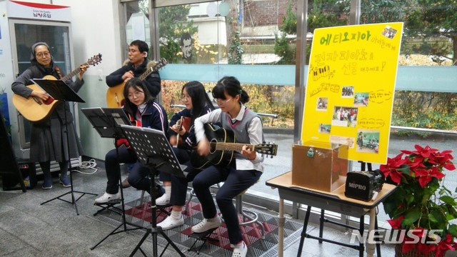 [광주=뉴시스] 송창헌 기자 = 광주 살레시오여중 기타반 학생들이 에티오피아 학생들에게 전자피아노를 기증하기 위해 최근 3주동안 매주 화요일 점심시간을 이용해 성금 모금을 위한 통기타 공연을 진행했다고 학교측이 18일 밝혔다. (사진=살레시오여중 제공) 2019.12.18photo@newsis.com