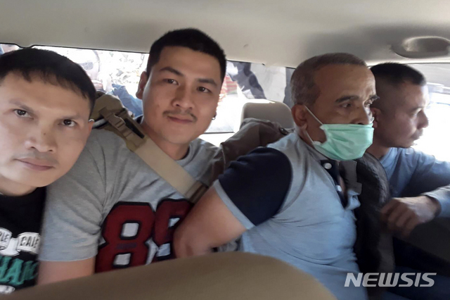 [팍총=AP/뉴시스] 태국 경찰이 배포한 사진으로 18일 북동부 기차역에서 체포된 연쇄살인범 솜티드가 마스크를 쓴 채 경찰에 호위돼 이송되고 있다.&nbsp; 2019. 12. 18.&nbsp; 