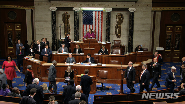 [워싱턴=AP/뉴시스] 18일(현지시간) 미국 하원 의원들이 도널드 트럼프 대통령의 탄핵소추안 중 제1항인 '권력남용' 부분에 대한 찬반 표결을 위해 좌석에서 일어나고 있다. 미국 하원은 찬성 227표 대 반대 177표로 제1항을 통과시켰다. 2019.12.19.