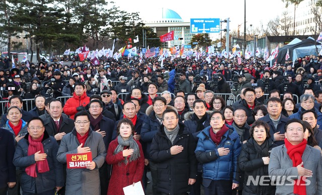 [서울=뉴시스] 고승민 기자 = 자유한국당 황교안 대표와 심재철 원내대표 등 의원들과 지지자들이 지난 19일 서울 여의도 의사당대로에서 열린 선거법 및 공수처법 규탄대회에서 국민의례를 하고 있다. 2019.12.19.photo@newsis.com