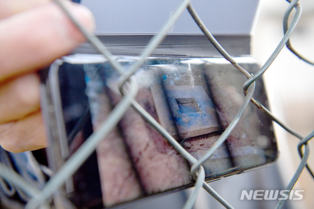 [광주=뉴시스] 류형근 기자 = 무연분묘(교도소 내에서 숨졌으나 연고가 없는 사람의 분묘) 이장 작업 중 유골 수십구가 발견된 20일 오후 광주 북구 옛 광주교도소 인근에서 5월단체 관계자가 휴대전화로 촬영한 유골 사진 등을 들어보이고 있다. 2019.12.20.&nbsp; hgryu77@newsis.com 