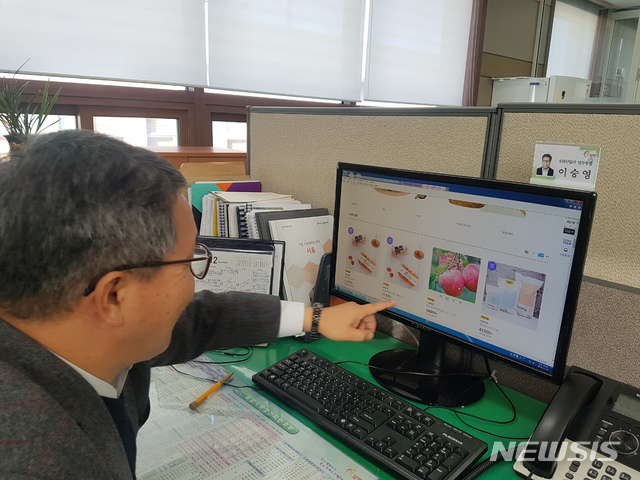 [밀양=뉴시스] 안지율 기자 = 경남 밀양시 농업기술센터 이승영 6차 산업과장이 이마트몰에서 지역의 감 말랭이와 얼음골 사과를 구매하고 있다. (사진=밀양시 제공) 2019.12.21.&nbsp; photo@newsis.com