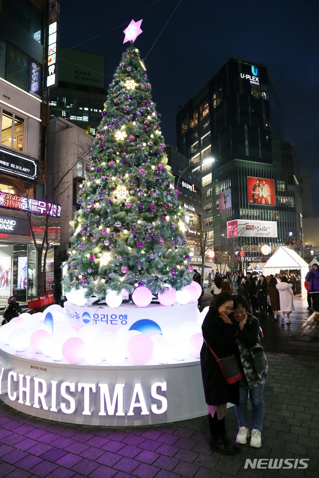 [서울=뉴시스]이윤청 기자 = 시민들이 21일 오후 서울 신촌 연세로와 명물거리에 경관조명으로 조성된 크리스마스 거리에서 기념촬영을 하고 있다. 29일까지 신촌 연세로와 명물거리에서는 매일 오후 3∼9시 소상공인과 중소기업 판로지원을 위한 '가치삽시다, 크리스마스 마켓'이 열린다. 2019.12.21. radiohead@newsis.com