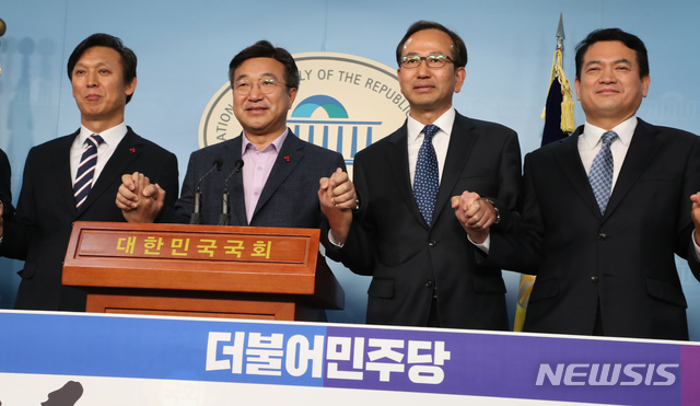 [서울=뉴시스]김명원 기자 = 윤호중 더불어민주당 사무총장이 22일 오전 서울 여의도 국회 정론관에서 김경욱(오른쪽) 전 국토교통부 2차관, 김영문(왼쪽) 전 관세청장, 강준석(오른쪽 두번째) 전 해양수산부 차관 입당 환영 기자회견을 마치고 손을 맞잡고 포즈를 취하고 있다. 2019.12.22.&nbsp; kmx1105@newsis.com 