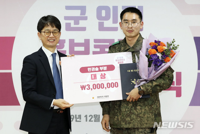 [서울=뉴시스] 고범준 기자 = 박재민 국방부 차관이 23일 서울 용산구 육군회관에서 열린 '군 인권 홍보 콘텐츠 공모전 시상식'에서 인권송 부문 대상 '꽃'이라는 창작곡을 출품한 육군 21사단 변현민 상병에게 상장을 수여 한 뒤 기념촬영을 하고 있다. 2019.12.23. bjko@newsis.com