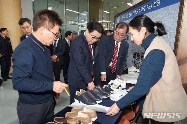 [창원=뉴시스] 강경국 기자 = 허성무 경남 창원시장 24일 창원시청에서 사회적기업인 '구두 만드는 풍경'이 판매하는 운동화를 고르고 있다. (사진 = 창원시청 제공) 2019.12.24.photo@newsis.com