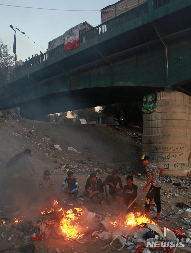 [바그다드= AP/뉴시스] 이라크 반정부 시위대가 보안군이 봉쇄한 바그다드 시내 교량 아래 티그리스강변에 집결해서 장기 농성을 하며 23일 현재 반정부시위를 두 달 째 이어가고 있다.