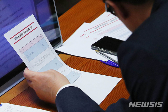 [서울=뉴시스] 장세영 기자 = 김한표 자유한국당 원내수석부대표가 24일 서울 여의도 국회에서 열린 본회의에서 공직선거법 개정안에 대한 무제한 토론(필리버스터)이 진행되는 동안 자유한국당의 무제한 토론 국회의원 당번표를 보고 있다. 2019.12.23.&nbsp; photothink@newsis.com