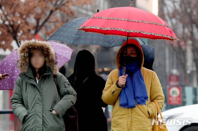 [서울=뉴시스]김병문 기자 = 비가 내리고 초미세먼지 농도 '나쁨' 수준을 보이는 지난 26일 오전 서울 종로구 광화문 네거리에서 마스크를 착용한 시민이 우산을 쓰고 있다. 2019.12.26. dadazon@newsis.com