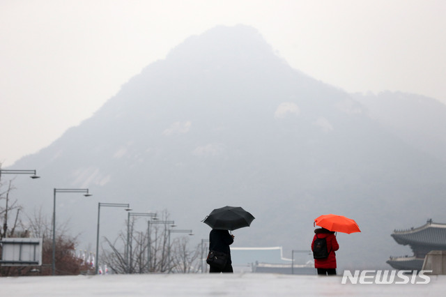 [서울=뉴시스]김선웅 기자 = 서울 지역에 비가 내린 지난 26일 오전 서울 종로구 광화문광장에서 우산을 쓴 시민들이 길을 걷고 있다. 2019.12.26. mangusta@newsis.com