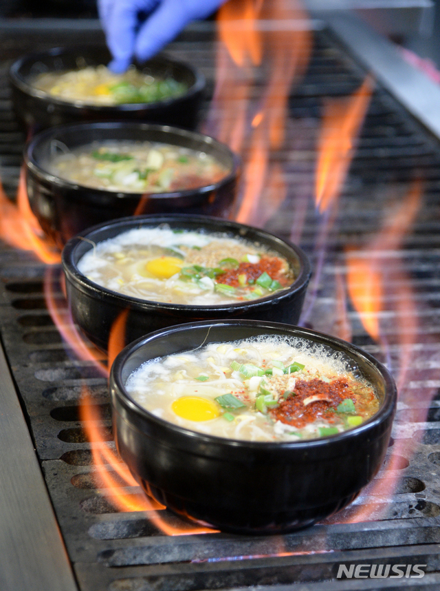 [전주=뉴시스] 김얼 기자= 19일 전북 전주시 삼백집 전주본점에 대표 음식 '끓이는 방식(직화)'의 콩나물 국밥이 맛있게 익어가고 있다. 2019.12.19. pmkeul@newsis.com