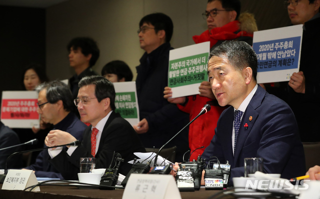 [서울=뉴시스]전신 기자 = 박능후 보건복지부 장관이 27일 서울 중구 더 플라자 호텔에서 열린 제9차 국민연금기금운용위원회에서 모두발언하고 있다. 뒤쪽으로 참여연대 경제금융센터 관계자등이 국민연금의 적극적 주주활동과 2020년 주주총회 주주권 행사를 촉구하는 피케팅을 하고 있다. 2019.12.27.&nbsp; photo1006@newsis.com