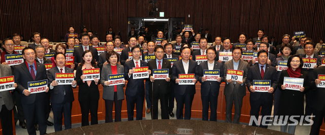 [서울=뉴시스] 고승민 기자 = 자유한국당 심재철 원내대표와 의원들이 27일 서울 여의도 국회에서 열린 당 의원총회에서 선거법과 공수처법을 반대하는 구호를 외치고 있다. 2019.12.27.kkssmm99@newsis.com