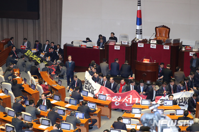 [서울=뉴시스] 고승민 기자 = 자유한국당 의원들이 27일 서울 여의도 국회에서 제373회국회(임시회) 제1차 본회의가 열리기 전 문희상 의장이 회기 결정 안건을 상정하기에 앞서 지난 필리버스터를 마친 선거법에 대한 표결을 먼저 처리할 것으로 알려지자 회기 결정 안건 선표결을 촉구하며 의장석을 둘러 앉아 농성을 하고 있다. 2019.12.27.  kkssmm99@newsis.com