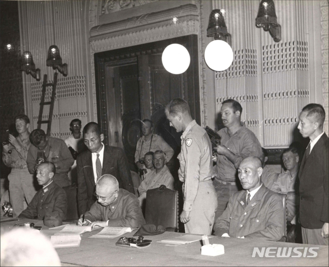 [서울=뉴시스]1945년 9월 9일 오후 4시 조선총독부 제1회의실(중앙청)에서 열린 종전협정에 대한 항복문서 조인식에서 조선총독 아베 노부유키(阿部信行) 대장, 조선군사령관 고즈키 요시오(上月良夫) 중장(왼쪽), 진해경비사령관 야마구치 기사부로(山口儀三郞) 제독(오른쪽)이 함께 참석해 항복문서에 서명하고 있다. (사진=미국 국립문서보관청) 2020.01.05.&nbsp;&nbsp; photo@newsis.com