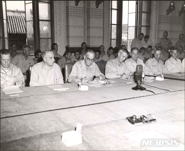 [서울=뉴시스]1945년 9월 9일 오후 4시 조선총독부 제1회의실(중앙청)에서 열린 종전협정에 대한 항복문서 조인식에서 태평양 방면 제24군사령관 하지 중장(오른쪽)과 태평양방면 해군사령관 킹커에드 대장이 서명하고 있다. (사진=미국 국립문서보관청) 2020.01.05. photo@newsis.com