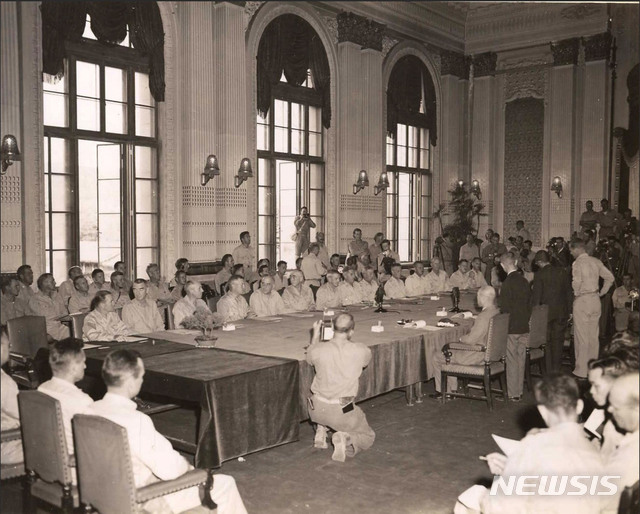 [서울=뉴시스]1945년 9월 9일 조선총독부 건물에서 열린 일본의 항복문서 조인식장에 들어가 역사적인 장면을 찍고 있는 조선영화사 소속 최희연((가운데 창틀 위) 사진기자. (사진=미국 국립문서보관청) 2020.01.05. photo@newsis.com