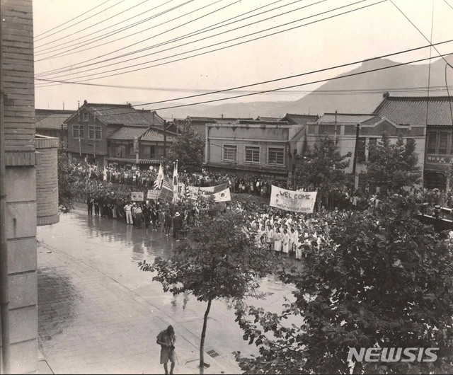[서울=뉴시스]1945년 9월 9일 오후 서울에서 시민들이 조선총독부(중앙청) 앞에서 연합국 국기를 들고 미국과 일본의 항복문서 조인식 종료를 기다리고 있다. (사진=미국 국립문서보관청) 2020.01.05. photo@newsis.com