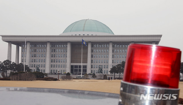 [서울=뉴시스]김병문 기자 = 여야의 격렬한 충돌이 예상되는 고위공직자범죄수사처(공수처) 설치법 표결을 앞둔 30일 오전 서울 여의도 국회가 주차된 경찰차 뒤로 보이고 있다. 2019.12.30.   dadazon@newsis.com