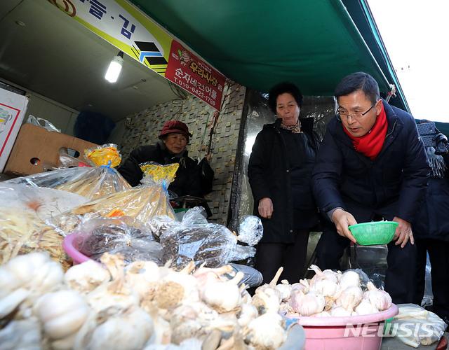[서울=뉴시스]박주성 기자 = 황교안 자유한국당 대표가 31일 오후 서울 대림동 우리시장을 방문해 마늘을 고르고 있다. 2019.12.31.&nbsp; park7691@newsis.com
