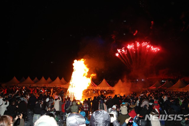 [제주=뉴시스] 1일 새벽 성산일출봉 일원에서 열린 성산일출축제에서 참석자들이 타오르는 불꽃을 보며 환호하고 있다.(제주도 제공)