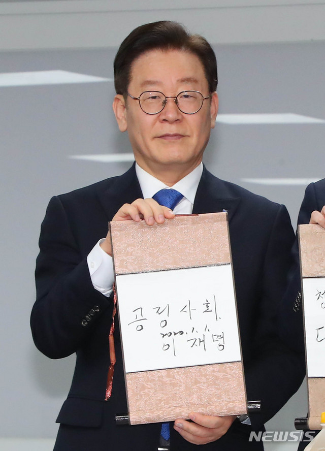 [서울=뉴시스] 장세영 기자 = 이재명 경기도지사가 1일 서울 여의도 더불어민주당 당사에서 열린 신년인사회에 참석해 신년 희망의 메시지를 적은 족자를 들고 있다. 2020.01.01. photothink@newsis.com
