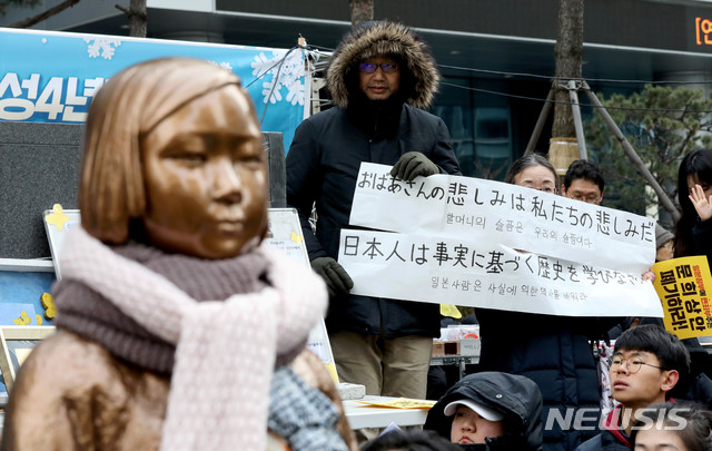 [서울=뉴시스]김병문 기자 = 새해 첫날인 지난 1일 오후 서울 종로구 옛 일본대사관 앞에서 정의기억연대 주최로 열린 일본군 성노예제 문제해결을 위한 제1420차 정기수요집회에서 참가자들이 일본어가 적힌 피켓을 들고 있다. 2020.01.01. dadazon@newsis.com