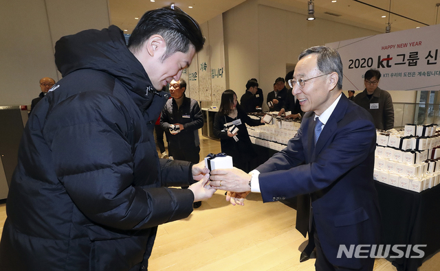 [서울=뉴시스]황창규 KT 회장이 2일 오전 서울 종로구 KT광화문빌딩에서 새해 첫 출근하는 직원들에게 격려 기프트 박스를 전달하고 있다. (사진=KT 제공) 2020.01.02.photo@newsis.com