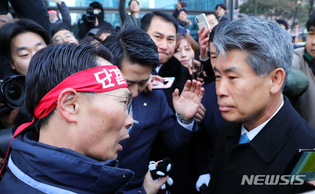 [서울=뉴시스]김근현 기자 = IBK기업은행 노조가 3일 오전 서울 중구 IBK기업은행 본점에 출근하는 윤종원 신임 기업은행장의 출근을 저지하고 있다. 이날 윤 신임 행장은 노동조합이 '낙하산 인사'에 반대하며 출근 저지 투쟁을 펼쳐 출근하지 못한 채 발걸음을 돌렸다. 2020.01.03. khkim@newsis.com 