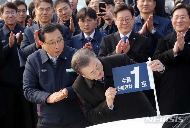 [평택=뉴시스]배훈식 기자 = 문재인 대통령이 3일 평택항에서 2020년 친환경차 수출 1호 '니로'에 기념 깃발을 달아주고 있다. 2020.01.03. dahora83@newsis.com