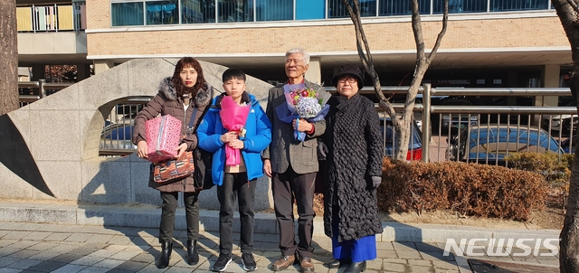  신풍초등학교 제111회 졸업식에서 3대 동문이 탄생, 기념사진을 찍고 있다. (사진 좌로부터 이지향씨, 이준엽군, 이문박씨 부부)(사진제공=이준엽군 가족)