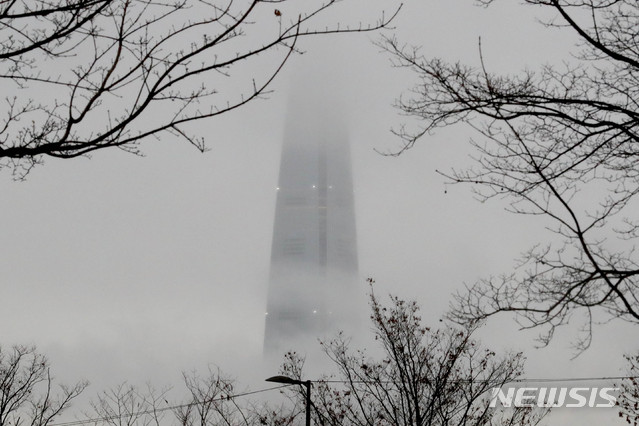 [서울=뉴시스]김병문 기자 = 겨울비가 내리는 지난 7일 오후 서울 광진구 뚝섬한강공원에서 바라본 롯데월드타워가 구름에 가려져 있다. 2020.01.07. dadazon@newsis.com
