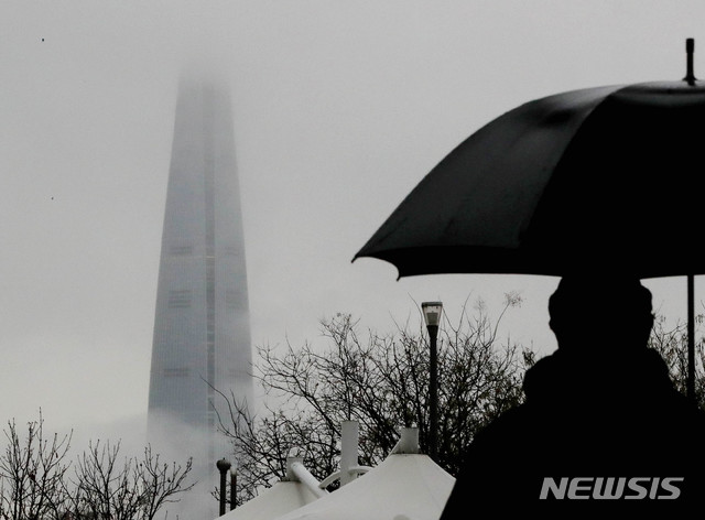 [서울=뉴시스]김병문 기자 = 겨울비가 내리는 지난 7일 오후 서울 광진구 뚝섬한강공원에서 바라본 롯데월드타워가 구름에 가려져 있다. 2020.01.07. dadazon@newsis.com