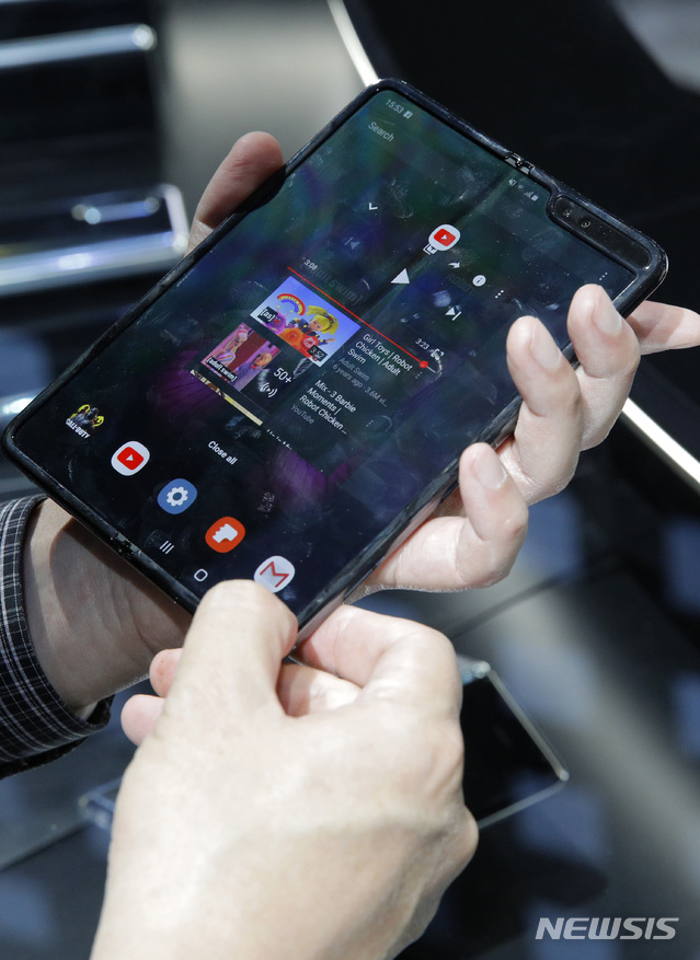 [라스베이거스=AP/뉴시스]세계 최대 가전·IT 전시회 'CES 2020'이 7일(현지시간) 미 네바다주 라스베이거스에서 개막한 가운데 삼성전자 전시관을 찾은 사람들이 갤럭시 폴드 5G 스마트폰을 체험하고 있다. 2020.01.08.