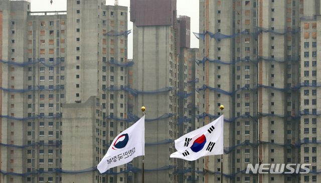 [과천=뉴시스] 최진석 기자 = 문재인 대통령이 지난 7일 신년사를 통해 "부동산 투기와의 전쟁에서 결코 지지 않을 것"이라고 밝혀 정부가 집값 안정을 위해 추가 대책을 내놓을 가능성이 커지고 있는 8일 경기 정부과천청사에서 바라본 한 신축아파트단지 앞에 대한민국정부기가 펄럭이고 있다. 2020.01.08. myjs@newsis.com 