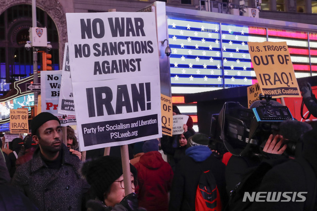 [뉴욕=AP/뉴시스]8일(현지시간) 시위대가 미국 뉴욕의 타임스퀘어에 모여 이란과의 전쟁 반대 시위를 벌이고 있다. 이란의 이라크 내 미군 기지 미사일 공격이 미국인 사상자가 없는 것으로 알려진 가운데 도널드 트럼프 미국 대통령이 대국민 연설을 통해 군사력 사용 자제 뜻을 밝히면서 양국 간 전면전 위험이 누그러진 양상을 보인다. 2020.01.09.