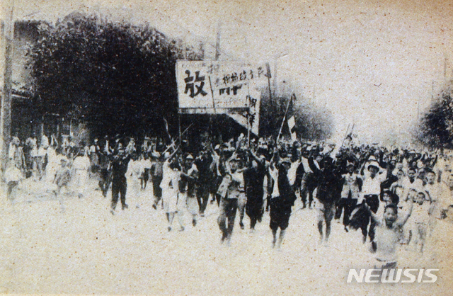 [서울=뉴시스]1945년 8월 16일 오후 ‘축 해방’, ‘민주정권수립’ 등 현수막을 들은 군중들이 환호하며 서울 시내를 행진하고 있다. (사진=미디어한국학 제공) 2020.01.12. photo@newsis.com