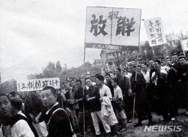 [서울=뉴시스]1945년 8월 16일 ‘우리 정권수립’, ‘축 해방’, ‘우리 조선 우리 정권’ 등의 현수막을 들은 군중들이 서울역 앞 광장에 서 있다. (사진=미디어한국학 제공) 2020.01.12. photo@newsis.com